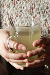 Hands holding lemon honey drink