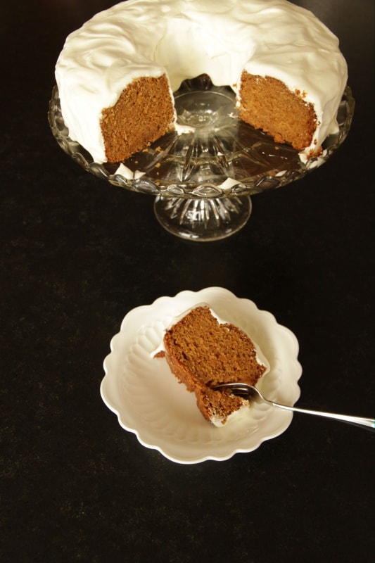 Slice of carrot cake, cake on platter in background