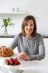 Krista sitting at table with bundt cake