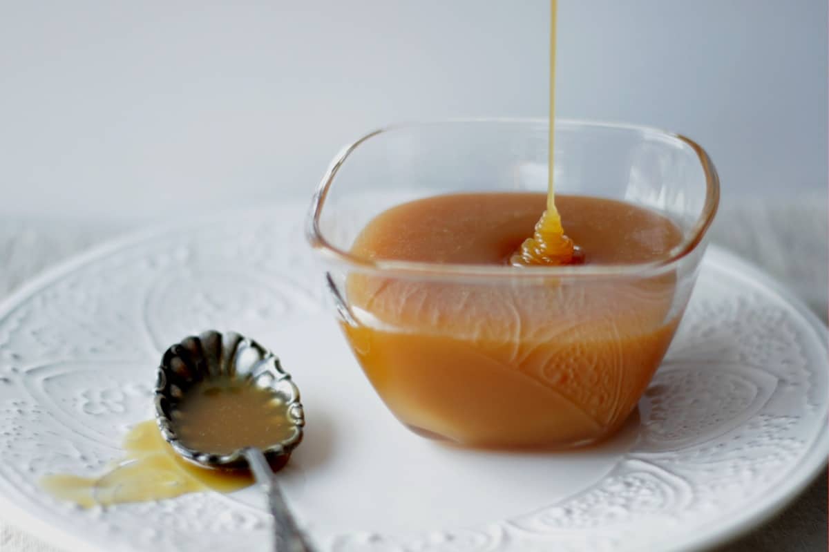 caramel sauce drizzling into small glass bowl