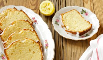 slices of lemon loaf cake on white plates on wooden surface