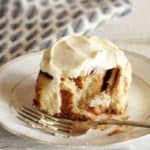 cinnamon roll on plate with fork