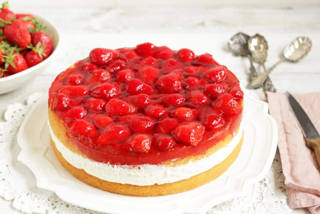 Diese hübsche Torte besteht aus einem flaumigen Biskuit, einer himmlischen Topfencreme und glasierten frischen Erdbeeren. Topfentorte mit Erdbeeren ist eine klassisch-österreichische Torte. Diese Rezept musst du ausprobieren!