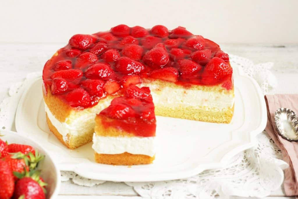 Diese hübsche Torte besteht aus einem flaumigen Biskuit, einer himmlischen Topfencreme und glasierten frischen Erdbeeren. Topfentorte mit Erdbeeren ist eine klassisch-österreichische Torte. Diese Rezept musst du ausprobieren!