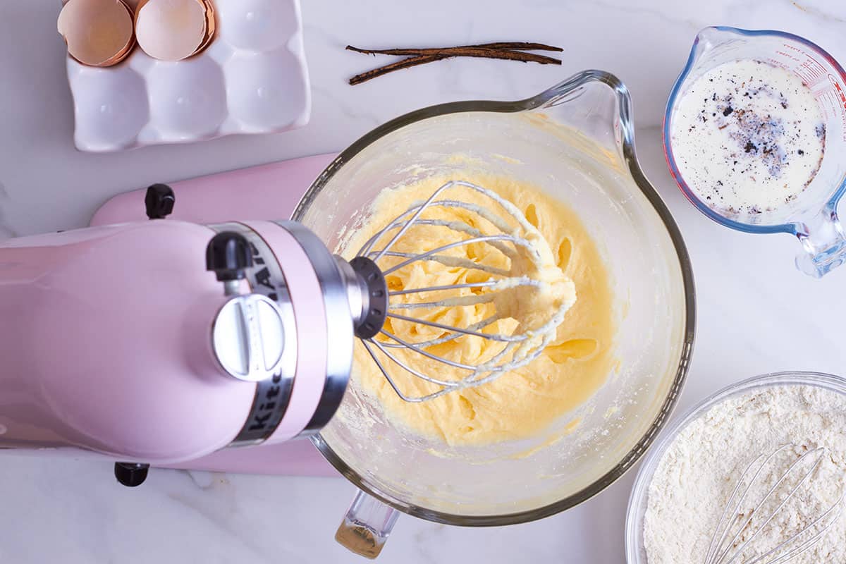 von oben: rosa Kitchen Aid mit Glasschüssel gefüllt mit gerührten, cremigen Teig