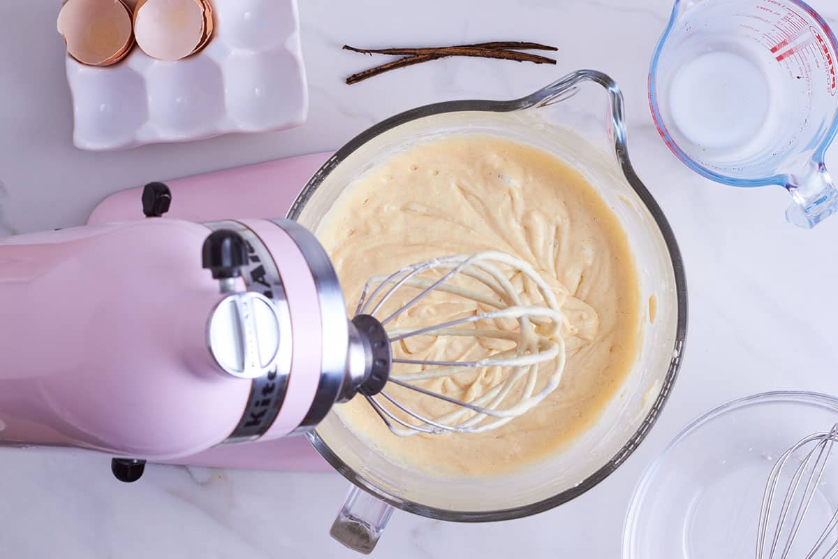 pink kitchen aid with glass bowl filled with vanilla cupcake batter